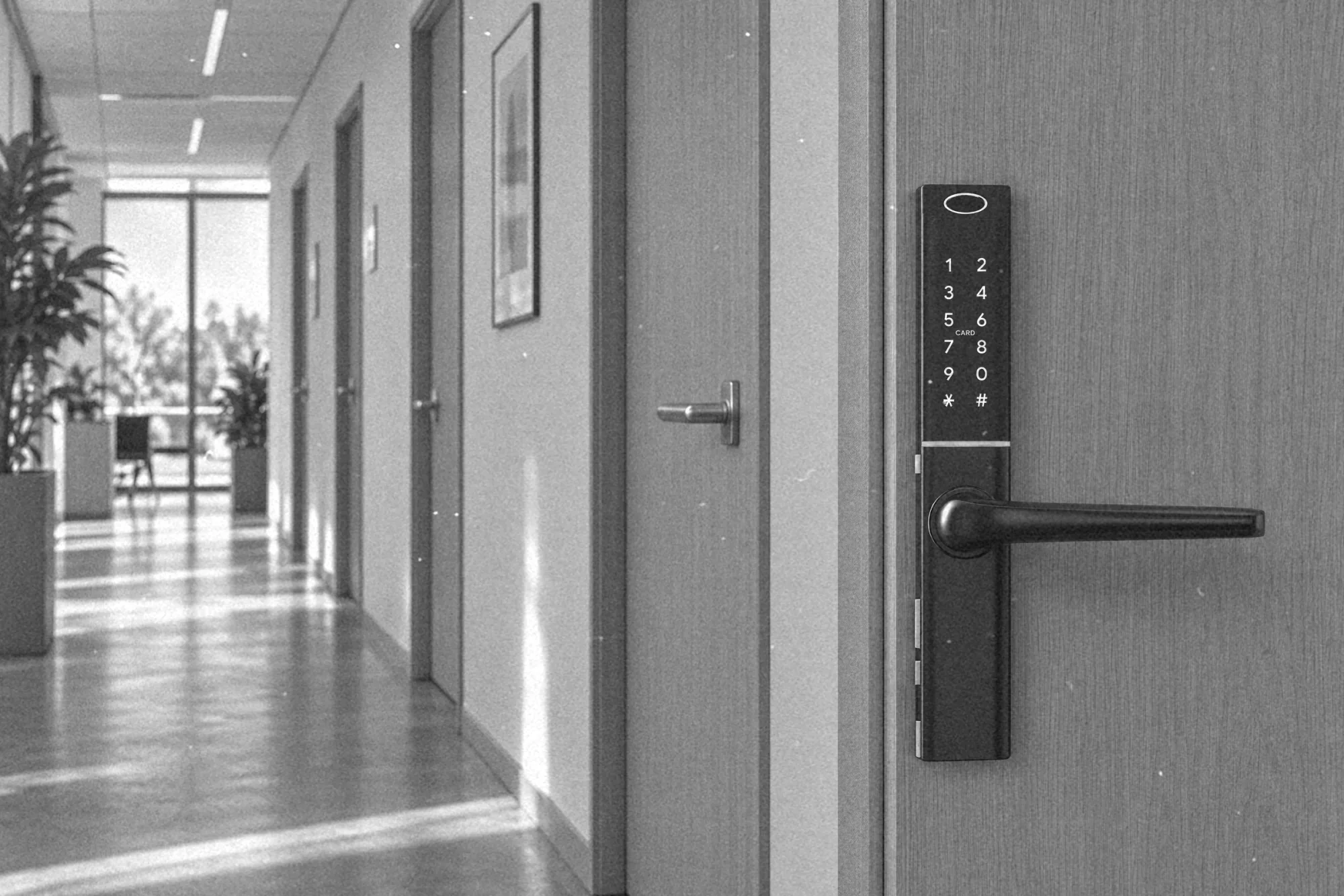 Rząd drzwi biurowych, przy wejściu do serwerowni elektroniczna klamka z czytnikiem kart