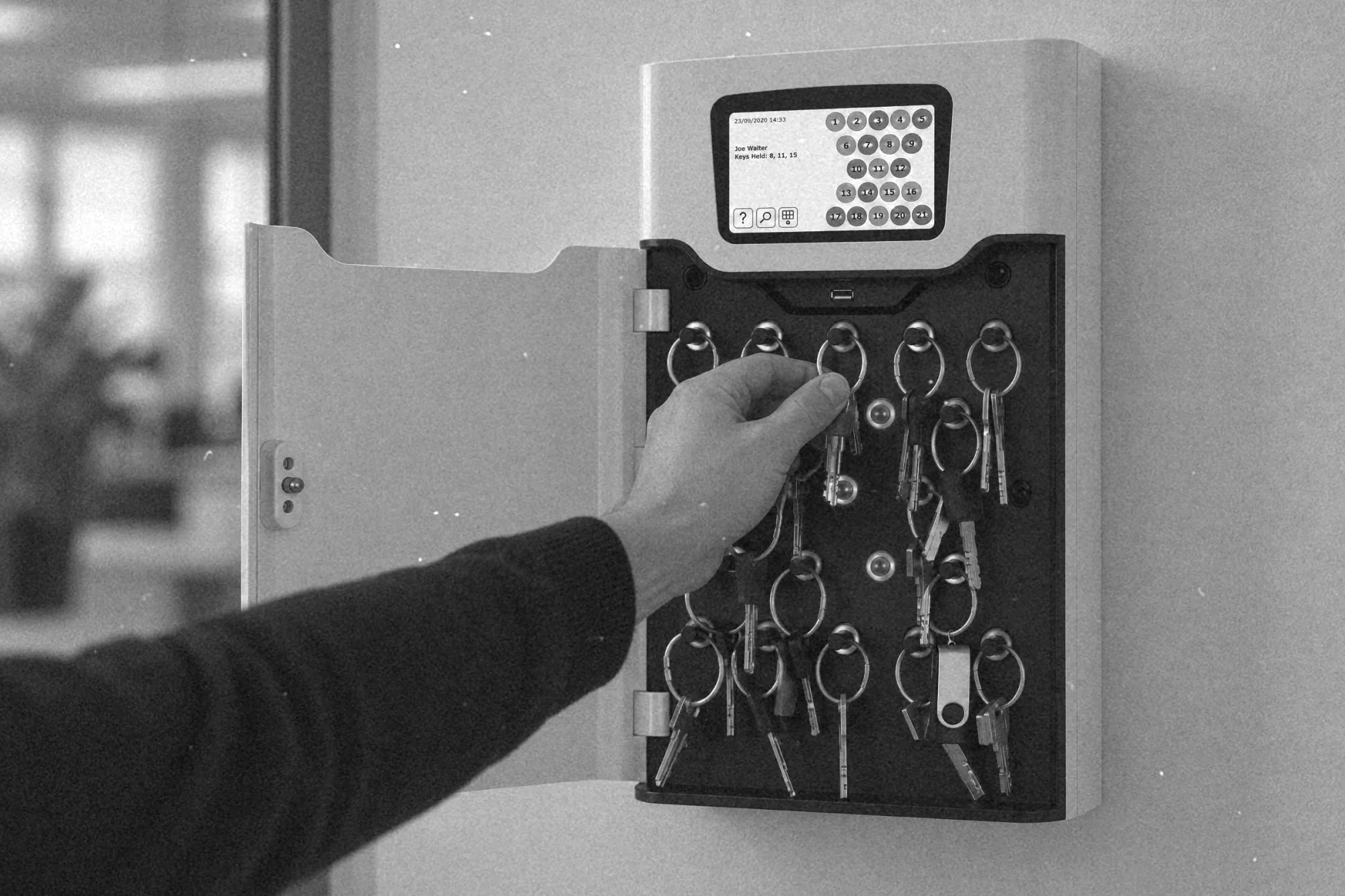 Pobieranie pęku kluczy z depozytora kluczy z terminalem na ścianie korytarza