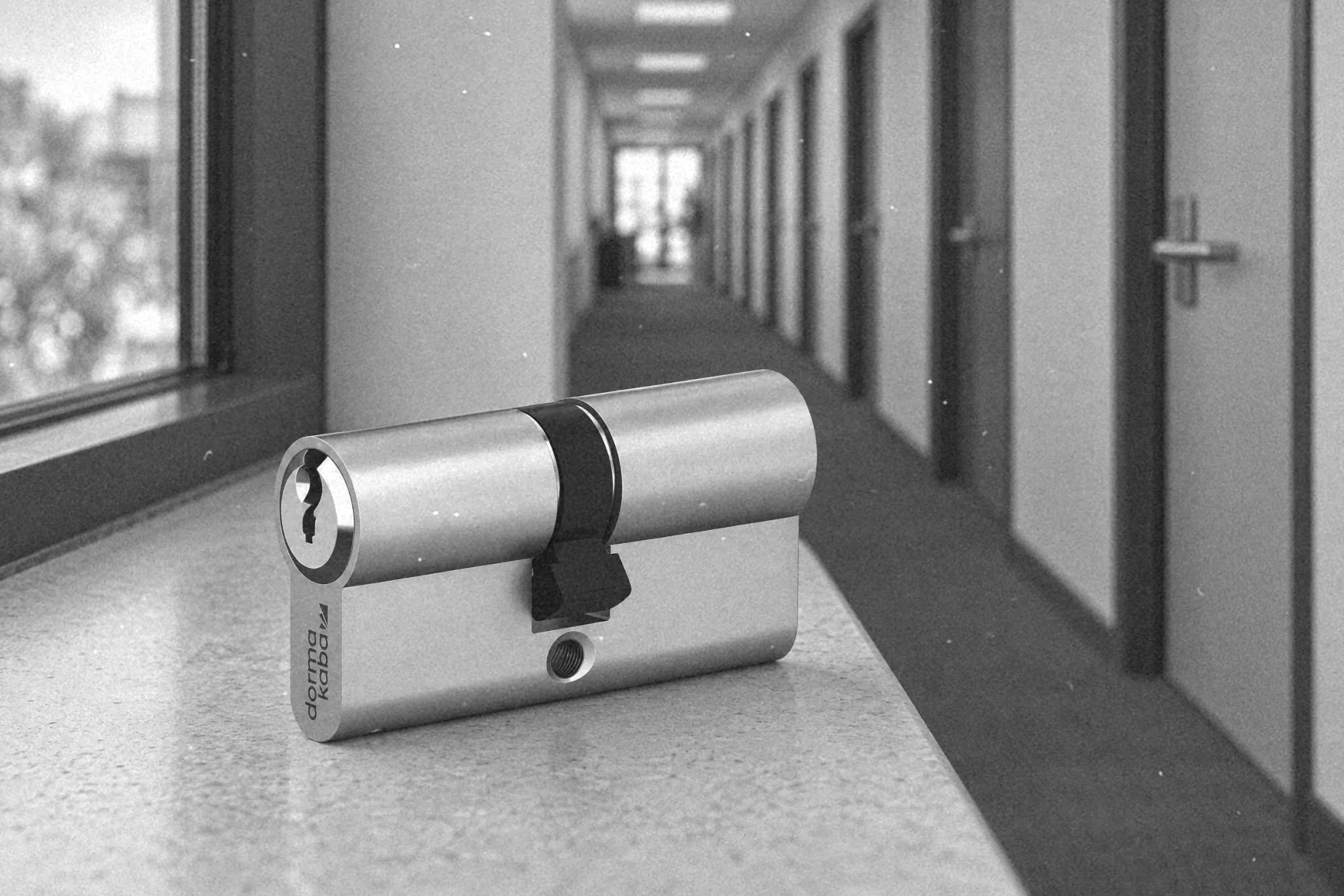 Pracownik recepcji hotelu trzyma klucz generalny, w tle tablica z kluczami