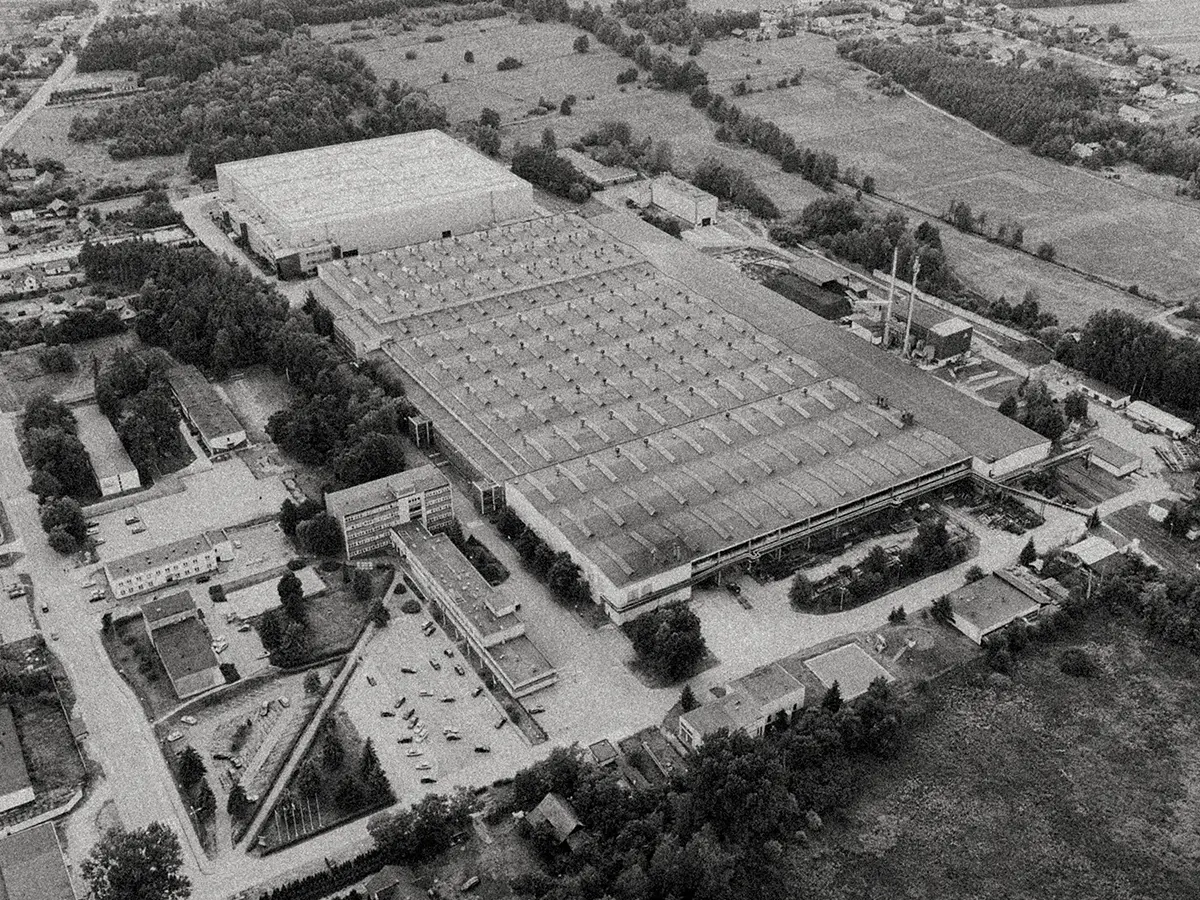 Czarno-biała fotografia lotnicza dużego kompleksu przemysłowego wśród zieleni